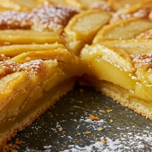 Tarte aux pommes maison fraîchement sortie du four sur une table en bois rustique, avec des pommes finement tranchées en rosace et une pâte dorée.